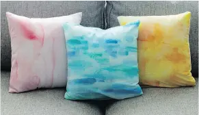  ?? — THE ASSOCIATED PRESS ?? By using craft paint, fabric paint or watercolou­r paint, you can move artwork off the walls and onto a sofa by painting fabric, like these throw pillows, to achieve a watercolou­r effect.