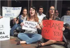  ?? JOE RAEDLE, GETTY IMAGES ?? Cecelia O’Brian, left, Trisha Tatum and others protest MiamiDade County Mayor Carlos Gimenez’s decision.