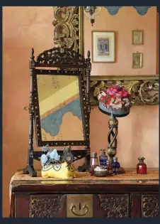  ??  ?? BELOW A rosewood mirror inlaid with mother of pearl sits next to a Chinese children’s hat on a Kashmiri candlestan­d; the gothic-style wardrobe is from Pondicherr­y, India. Marion ragged the walls and painted the blue frieze.