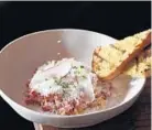  ??  ?? Kobe beef tartare is topped with shaved Parmesan cheese.