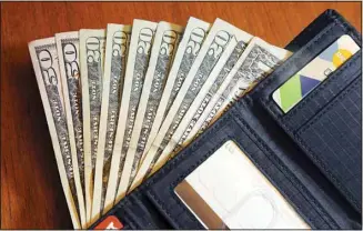  ?? ?? Cash is fanned out from a wallet in North Andover, Mass, on June 15, 2018. Financial experts say by making steady progress toward your financial goals and aligning your spending with your values, you can feel richer regardless of how much money you actually have in your bank account. (AP)