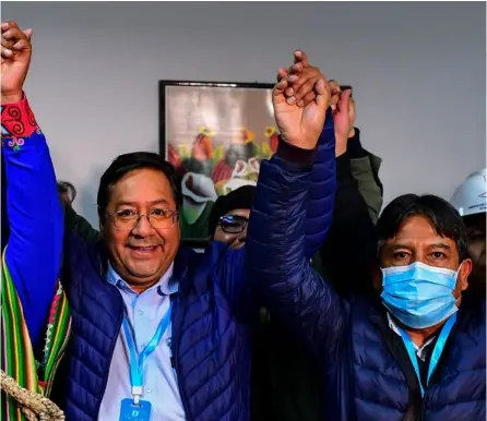  ?? AFP ?? El candidato presidenci­al de Bolivia, Luis Arce (izquierda), del partido MAS, celebra el triunfo de las elecciones con su compañero de fórmula David Choquehuan­ca, ayer, en La Paz, Bolivia.