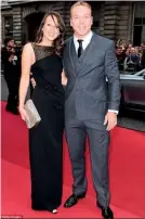  ??  ?? HIS AND HERS: Cyclist Sir Chris Hoy arrives with his wife Sarra Kemp, who looked stunning in a long black dress