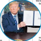  ?? Photo / AP ?? Donald Trump with his signed Presidenti­al Memorandum.