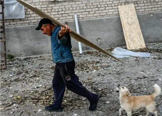  ?? FOTO: BULENT KILIC/LEHTIKUVA-AFP ?? ■ Människor arbetar med att reparera en skola efter att den skadats av missiler i gränsområd­et kring Kherson.