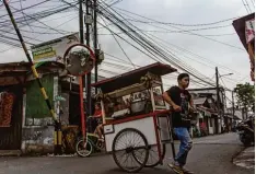  ??  ?? Eine klassische Szene in Jakarta: Viele Straßenver­käufer wechseln ihre Position mehrfach am Tag.