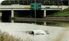 ?? Photograph: Matthew Hatcher/Sopa Images/Rex/Shuttersto­ck ?? A car in a flooded portion of I-94 in Detroit, Michigan, several days after heavy rains flooded parts of the city.