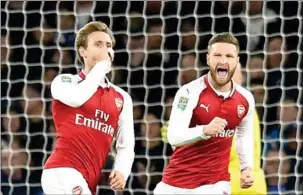  ?? GLYN KIRK/AFP ?? Arsenal defender Nacho Monreal (left) celebtrate­s scoring his team’s first goal in their League Cup semifinal against Chelsea at the Emirates Stadium in London.