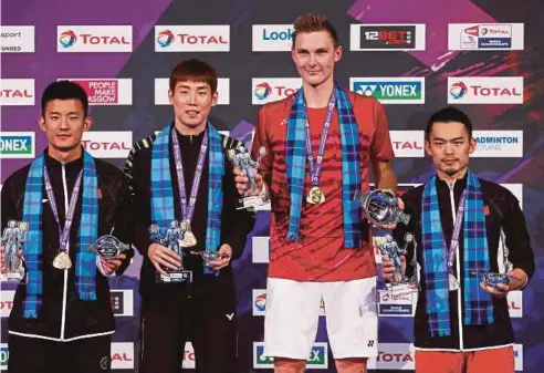  ??  ?? AXELSEN (dua dari kanan) memegang trofi Kejuaraan Dunia di London.