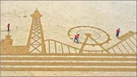  ?? AFP ?? An aerial photo shows a giant sand art, depicting the iconic Pier Tower and rides of Blackpool in England. It was drawn by artists to promote tourism following the end of Covid-19 restrictio­ns.