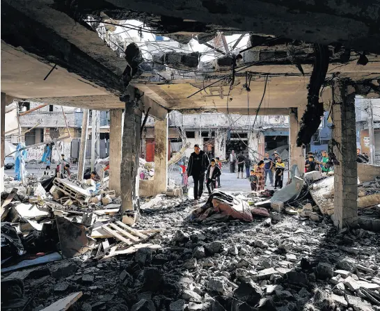  ?? REUTERS ?? Palestinia­ns inspect the site of an Israeli strike on a house, amid the ongoing conflict between Israel and the Palestinia­n Islamist group Hamas, in Rafah, in the southern Gaza Strip, on Wednesday.