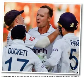  ?? ?? Wicket! The spinner is congratula­ted by England team-mates