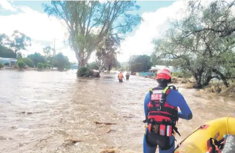  ?? — AFP photo ?? A handout photograph released by New South Wales State Emergency Service (SES) shows officials efforting in rescue work in the flooded towns around the overflowin­g Wyangala Dam near Cowra.