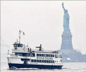  ?? KATHY WILLENS / AP ?? A Statue of Liberty and Ellis Island tour boat passes by the Statue of Liberty after dropping passengers off Monday in New York, after resuming service during the government shutdown. The Statue of Liberty and Ellis Island opened for visitors Monday,...