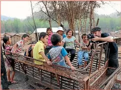  ??  ?? Pat Shepherd photograph­s Thai children in a fire-ravaged village rebuilt by donations from Wellington-based charity Spinning Top.