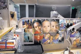  ??  ?? Above: Annette Crespo, arrested on drug charges in 2000, is an intern at Checkr. Below: Her cubicle at Checkr displays a collage of pictures of her grandkids and other family.