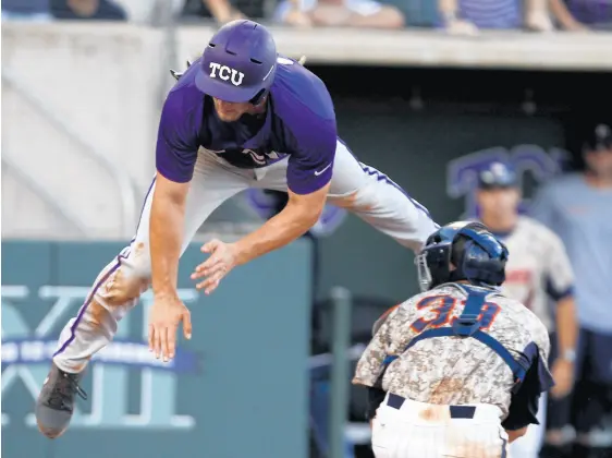  ??  ?? TCU’s Jerrick Suiter, left, tries to leap past Pepperdine catcher Aaron Barnett during a 2014 NCAA Super Regional game.