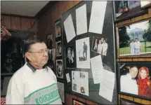  ??  ?? Lorne Harasen looks over a framed collage of some of his memories of Bing Crosby, whom he interviewe­d on-air for seven Christmase­s. On the right is a photo of Harasen with Crosby’s widow, Kathryn.