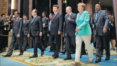  ?? REUTERS ?? Leaders, from left, Indonesian President Joko Widodo, French President Francois Hollande, China’s President Xi Jinping, Russian President Vladimir Putin, German Chancellor Angela Merkel and South African President Jacob Zuma arrive for the opening...