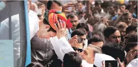  ??  ?? Congress Vice-President Rahul Gandhi being presented a turban by supporters during a roadshow at Banaskanth­a in Gujarat on Sunday