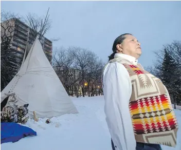  ?? LIAM RICHARDS ?? Alvin Baptiste stands watch at a teepee containing a sacred fire that burned during the Missing and Murdered Indigenous Women and Girls hearings in Saskatoon. The Saskatoon hearings wrapped up Thursday.