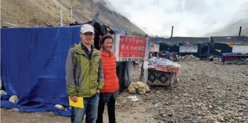  ??  ?? Yang Tao (left), a scholar from China Tibetology Research Center, and a Tibetan woman who operates the tent restaurant behind them. In August 2016, Yang conducted a survey at the Qomolangma base camp and interviewe­d local Tibetans engaged in tourist service on how the boom of tourism had impacted their lives and the local ecological environmen­t. courtesy of Yang Tao