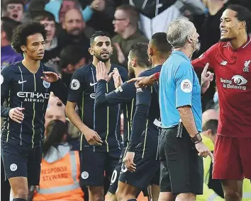  ?? Reuters ?? Manchester City’s Riyad Mahrez (second left) with teammates as referee Martin Atkinson talks with Liverpool defender Virgil van Dijk and awards Manchester City a penalty yesterday.