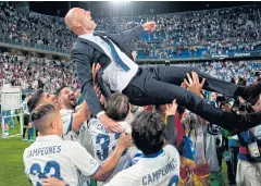  ?? AFP ?? Real Madrid players lift coach Zinedine Zidane at the end of match against Malaga.