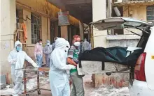  ?? AFP ?? Medical staff remove a body from a vehicle upon arriving at the Civil Hospital in Ahmedabad.