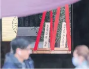  ?? AFP ?? A wooden plaque showing the name of Japanese Prime Minister Yoshihide Suga is seen with a ‘masakaki’ tree that he sent as an offering to the controvers­ial Yasukuni shrine.