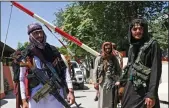  ?? WAKIL KOHSAR/AFP VIA GETTY IMAGES ?? Taliban fighters stand guard along a roadside near the Zanbaq Square in Kabul on Aug. 16, after a stunningly swift end to Afghanista­n’s 20-year war.