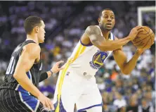  ?? Stephen Lam / Special to The Chronicle ?? Warriors forward Andre Iguodala looks to pass around Aaron Gordon of Orlando in a March 16 game at Oracle Arena.