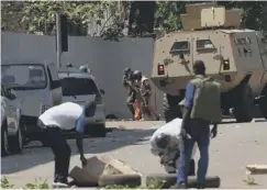  ??  ?? Bystanders watch security personnel move into position