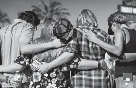  ?? JOHN LOCHER/AP PHOTO ?? People pray Sunday at a makeshift memorial in Las Vegas for victims of the Oct. 1, 2017, mass shooting in the city.