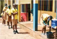  ??  ?? Students line up to wash their hands while maintainin­g a safe distance at a school in Yaounde, capital of Cameroon, on June 1