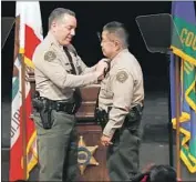  ?? Mel Melcon Los Angeles Times ?? L.A. SHERIFF Alex Villanueva gives a pin to Assistant Sheriff Tim Murakami at a December ceremony. Murakami was named second-in-command Monday.