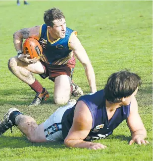  ??  ?? Warragul Industrial­s player Dean Johnson wins the contest against Catani’s Nathaniel Rodda