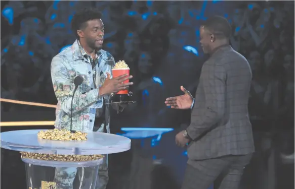  ?? CITIZEN NEWS SERVICE PHOTO BY MATT SAYLES ?? Chadwick Boseman, left, gives his best hero award for his role in Black Panther to James Shaw Jr., who is credited with saving lives during a shooting at a Waffle House in Antioch, Tenn., at the MTV Movie and TV Awards at the Barker Hangar in Santa...