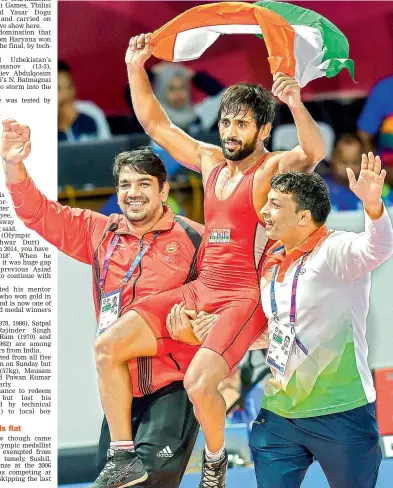  ?? PTI ?? Bajrang Punia holds the tricolour as he is carried around after winning the men’s freestyle wrestling (65kg) final against Daichi Takatani of Japan in Jakarta on Sunday. Punia won the bout 11-8. —