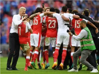  ??  ?? Wenger celebrates with his players after their FA Cup final victory (Getty)