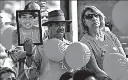  ?? GUSTAVO ANDRADE/AP ?? A man holds a portrait of a victim who died in the 2019 dam disaster last year in Brumadinho city, Minas Gerais state, Brazil. On Saturday, relatives of victims had a memorial.