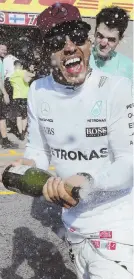  ?? AP PHOTO ?? SHOWERED WITH AFFECTION: Lewis Hamilton celebrates with champagne after winning the Canadian Grand Prix yesterday in Montreal.