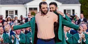  ?? David J. Phillip/associated Press ?? Jon Rahm, of Spain, puts the green jacket on winner Scottie Scheffler after the Masters golf tournament at Augusta National Golf Club Sunday in Augusta, Ga.