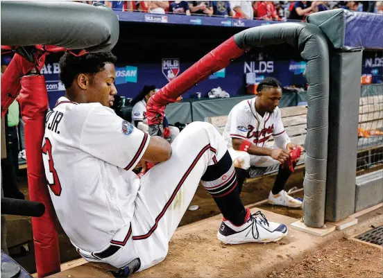  ?? CURTIS COMPTON PHOTOS / CCOMPTON@AJC.COM ?? Ronald Acuna Jr. and Ozzie Albies sit dejected in the dugout while the Los Angeles Dodgers celebrate winning their National League Division Series after a 6-2 victory Monday at SunTrust Park. The two are among three 2019 projected starters who will be 25 years old or younger next season.