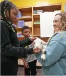  ?? ?? Duquesne Elementary teacher Amber Toner holds a lamb for second graders Regan Hunter, 8, and Major Williams, 8.