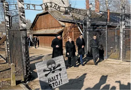  ?? AP ?? Flanked by Auschwitz-Birkenau museum staff, German Chancellor Angela Merkel and Polish Prime Minister Mateusz Morawiecki visit the former Nazi death camp.