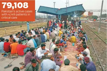  ?? AP ?? 79,108 Pakistan’s active cases with 4,149 patients in critical care
People have iftar at a free food distributi­ng point at a railway station in Lahore on Friday. Pakistan hopes to receive 15 million doses through the COVAX programme by next month.