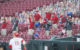  ?? AARON DOSTER — THE ASSOCIATED PRESS ?? Members of the Cincinnati Reds’ grounds crew react as Reds’ Joey Votto runs the bases after hitting a two-run home run during the first inning of the team’s baseball game against the Milwaukee Brewers in Cincinnati, Wednesday.