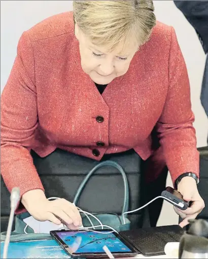  ?? MICHAEL SOHN / AP ?? La canciller alemana, Angela Merkel, manejando ayer una tableta en una reunión de gobierno en Potsdam