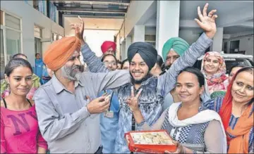  ?? GURPREET SINGH/HT ?? Gurpreet Singh, who topped the state in the Punjab School Education Board (PSEB) Class10 exam, celebratin­g with his father Davinder Singh, mother Narinder Kaur and others in Ludhiana on Tuesday.